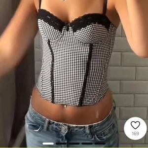 Svartvit rutig korsett - Snygg svartvit rutig korsett med spetsdetaljer upptill. Den har justerbara axelband och en tight passform. Perfekt för en utekväll eller fest! 🖤