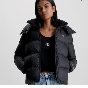 Svart pufferjacka från Calvin Klein - Säljer en snygg svart pufferjacka från Calvin Klein. Perfekt för både höst och vinter, inga defekter eftersom den är alldeles ny