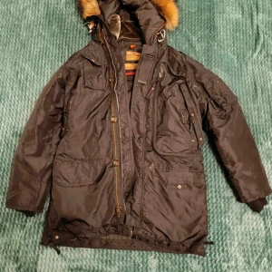 Parajumper - Stilren Parajumper Parka i storlek S, helt rörfri. Denna jacka kombinerar elegans med funktionalitet och håller dig varm i alla väder. Perfekt för både vardag och äventyr. Missa inte chansen att göra den till din.  Se bild för se dom små skravankerna