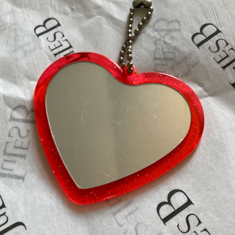 Supergullig hjärtformad nyckelring med motiv från 'Charming Junkie' av Ryoko Fukuyama. Den är röd med vita prickar och har en spegel på baksidan. Repor finns. Perfekt för att piffa upp din väska eller nyckelknippa! Vintage furoku från Japan ❤️. Asusteet.