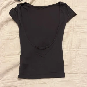 Backless top - Säljer denna mörkgrå backless top från Gina, säljer pga att den inte kommer till användning längre. Tröjan är i fint skick