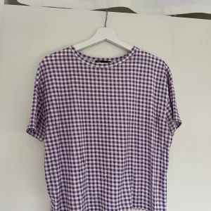 Rutig t-shirt  - Rutig t-shirt från Zara i vit och lila. Bra skick.