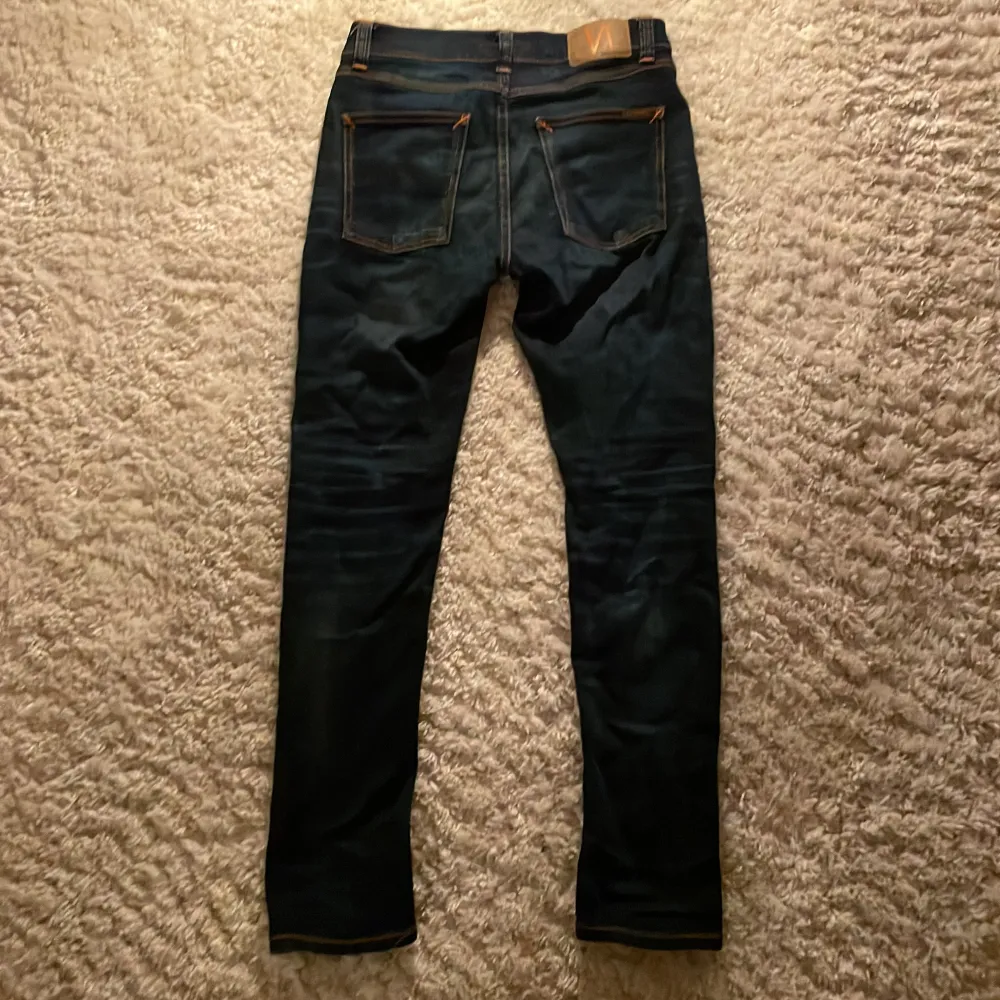 Säljer ett par snygga Nudie jeans som är storlek 27/30 men passar 30/30, jeansen är mörkblå, passformen är slimfit. Jeans & Byxor.