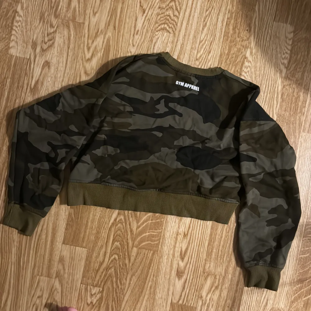 Säljer camouflage tröja från Better Bodies i storlek XS. Den har ett stort tryck med texten 'BETTER BODIES' i vitt på framsidan. Tröjan är perfekt för en avslappnad stil på gymmet och har långa ärmar med ribbade muddar. oversize. Magtröja Ny oanvänd.. Tröjor & Koftor.