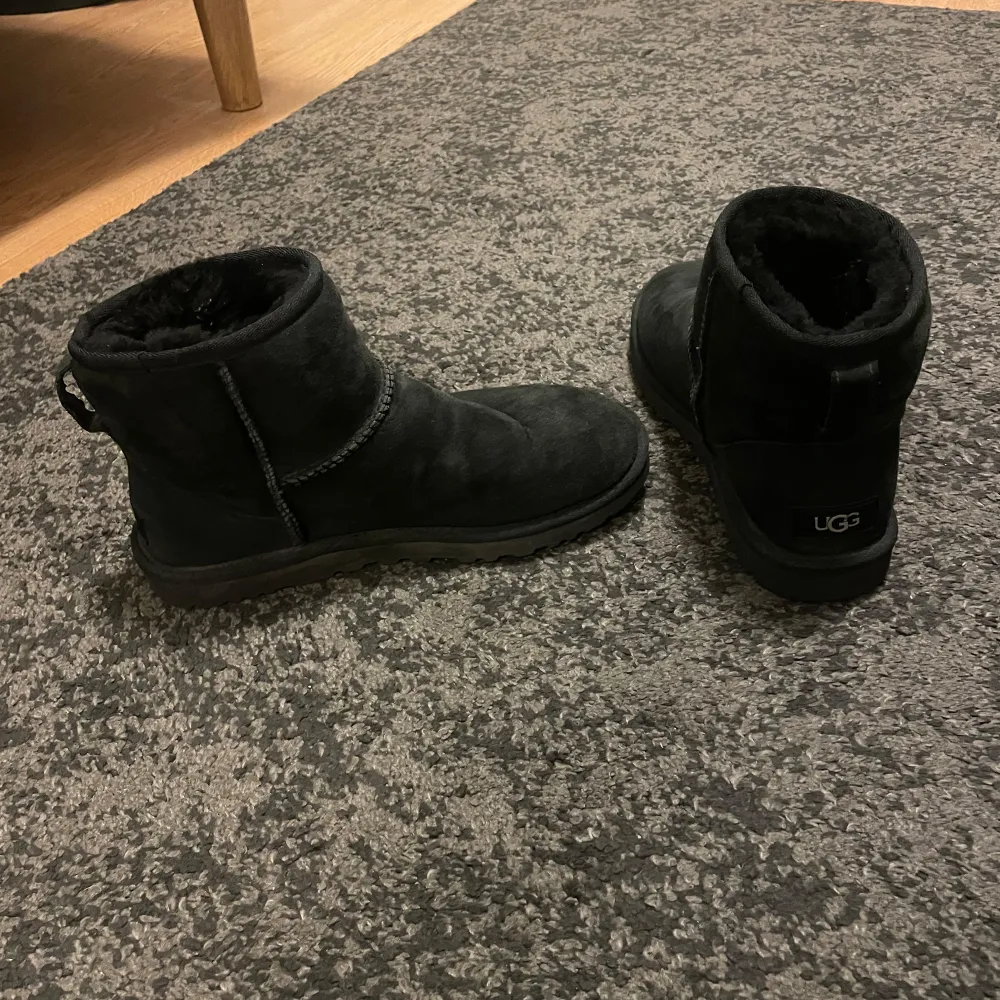Säljer ett par svarta UGG mini II i storlek 41. Skorna är i bra skick och endast använda en vinter. Boxen fås med. Nypris 2299 kr. Kengät.