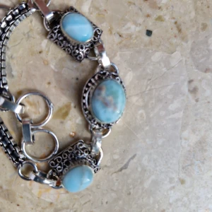 Ny armband med larimar stenar  - Armband med 3 larimar stenar  Armbandets längd är ca 20 cm Stenarstorlek är ca 9*6, 12*9, 8*6 mm Tillverkad av silver blandat med messing