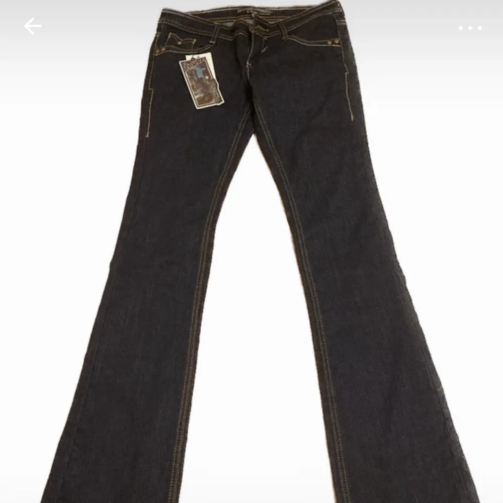 Mörkblåa lågmidjade bootcut jeans.  Midjemåttet är 39, innerbenslängd är 87 och ytterbenslängden är 107. . Jeans & Byxor.