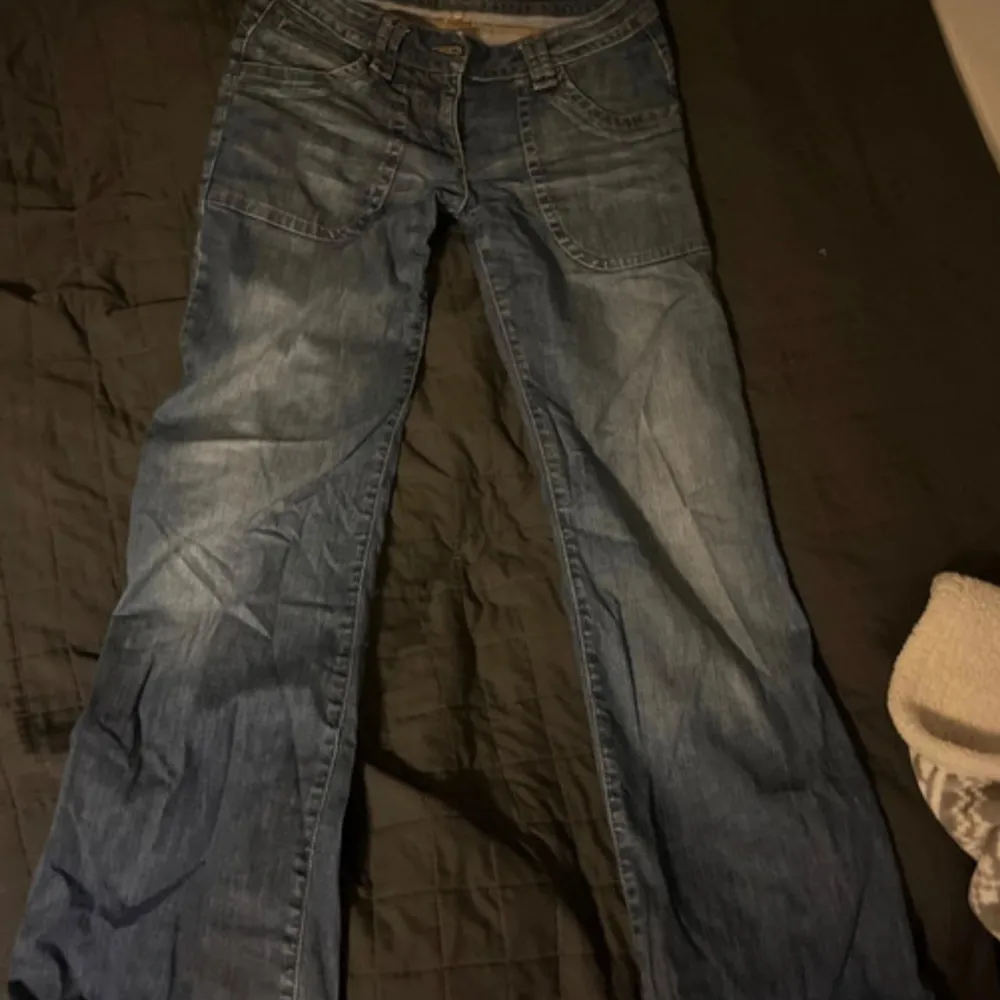 Säljer ett par snygga blå jeans från Sandro i bra skick. De är tillverkade i 98% bomull och 2% elastan, vilket gör dem både bekväma och stretchiga. Perfekta för vardagsbruk med en klassisk straight fit. Passar till alla tillfällen!. Farkut & Housut.