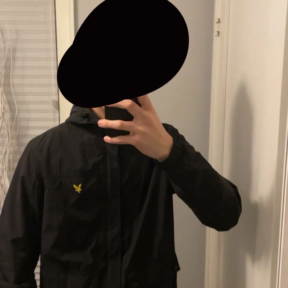 Säljer en snygg svart jacka från Lyle & Scott i storlek S. Den har en huva och är långärmad, perfekt för höst och vår. Jackan har en dragkedja och samt en liten gul logga på bröstet. Den är i mycket bra skick och passar till vardagar. Jackor.