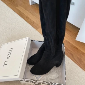 Lårhöga klackar - Lårhöga Tiamo-klackar, använda 1-2 gånger endast lite dammiga från att inte ha använts, lätt att damma bort och som nya då!   Storlek 37, nypris 799kr med lådan kvar.