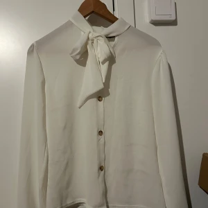 Vit blus med rosett - Aldrig använd, bara testad. Jättefin men passar tyvärr inte mig.