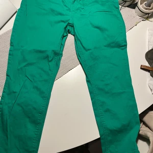 Gröna jeans från Vero Moda - Säljer ett par snygga gröna jeans från Vero Moda. De har en klassisk design med dragkedja och knapp framtill. Perfekta för att liva upp garderoben med lite färg! Passar både till vardags och festliga tillfällen. 🟢👖