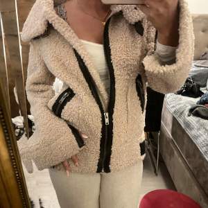 Mysig beige teddyjacka från Zara i storlek XS. Perfekt för höst och vinter med sitt varma material. Jackan har en cool dragkedja och flera fickor för extra stil och funktion. Den är långärmad och har en skön passform som håller dig varm och trendig.