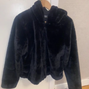 Svart pälsjacka från Only - Mysig svart pälsjacka från Only i mycket bra skick. Perfekt för kalla höst- och vinterdagar. Jackan har en luva och en dragkedja. Storlek L men liten i storleken och passar mig som har S/M vanligtvis. Skriv om ni har frågor!❤️
