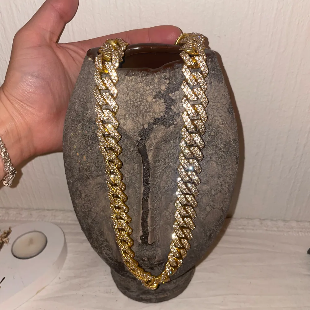 Säljer ett snyggt och glittrigt halsband i guld. Perfekt för att lyfta vilken outfit som helst med lite extra bling. Halsbandet har en chunky design med stora länkar som är täckta av glittrande stenar. Passar perfekt för festliga tillfällen eller när du bara vill känna dig extra glamorös. 🥳✨. Accessoarer.