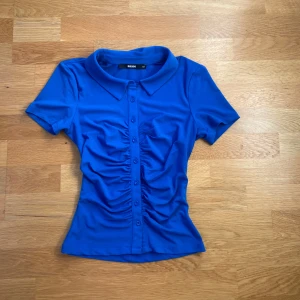 Blå tight-topp Bik Bok - Blå, kortärmad och tight men stretchiga topp från Bik Bok. Storlek XS.