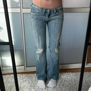 Lågmidjade Bootcut jeans  - Lågmidjade jeans med slitningar/hål. Uppskattad storlek S. Midjemått:39 innerbenslängd:76. Obs se sista bilden. Köp sker via köp nu, jag postar inom 24h. Kvar tills markerad såld 