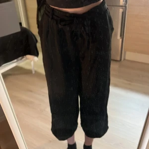 Svarta byxor med knytband - Säljer ett par svarta byxor i loose fit med knytband i midjan. De är perfekta för en avslappnad stil och har en bekväm passform. Byxorna är i  bra skick. 