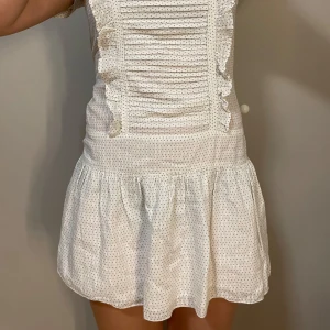 Vit kortklänning med volangdetaljer - Söt vit kortklänning med små prickar och volangdetaljer framtill. Jätte fina detaljer ☺️☺️