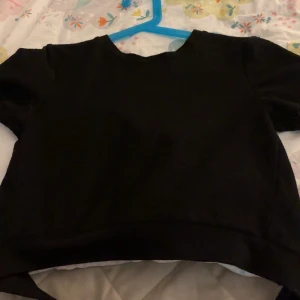 Topp - En svart fin topp med öppen rygg, de går att knyta en fin rosett på ryggen, säljs pgd av att den ej används, de är en magtröja också!! (Kan skicka bilder på hur den sitter på, det är bara att be om de) Den sitter som en S-XS!! (Pris kan diskuteras) 