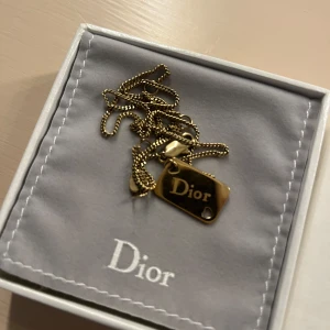 Guldhalsband från Dior - Elegant guldhalsband från Dior med en stilren bricka. Perfekt för att ge en lyxig touch till din outfit. Kommer i originalförpackning. Kedjan är 40. Säljer eftersom jag är en silver person egentligen. Såklart äkta 
