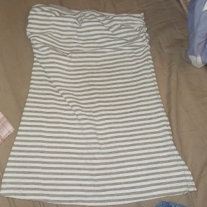 Randig strapless topp  - En topp utan straps, grå och vit. Finns resårband så att den ska sitta bra och inte glida ner :D