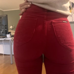 Röda manchesterbyxor från Rolla's - Snygga röda manchesterbyxor från Rolla's med hög midja och bootcut-stil. Perfekta för att ge en färgklick till din outfit. Byxorna har en klassisk design med fickor och en bekväm passform. Nypris 1200kr