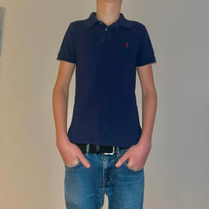 Polo Ralph Lauren Pike Marinblå Storlek xs/s - Det här är en stilren fräsch marinblå polo ralphlauren piké i storlek xs/s.☺️ Jag på bilden är 1,85 lång och den är för liten som man ser, den passar för längden 170-180cm.😉 Orginalpris: 1395kr(mitt pris där nere) . Priset kan diskuteras, och även sänkas vid snabb affär! Skulle säga att denna är 8/10 skick!😊😊För frågor så är det bara att skicka iväg ett meddelande så svarar jag så snabbt som möjligt!