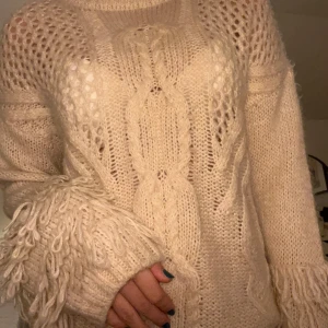 stickad tröja med fransar - Kräm vit stickad tröja med fransar på armen 