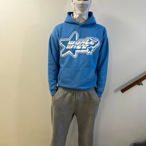 Blå hoodie puff print - Säljer en blå hoodie från  New yorker med en stor vit stjärnlogga på framsidan. Tröjan har en klassisk ficka och en bekväm huva. Perfekt för en avslappnad stil. Storlek M