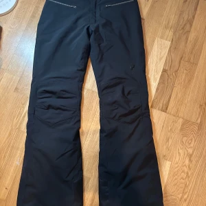 Svarta byxor från Peak Performance - Snygga svarta skidbyxor från Peak Performance i storlek XS. Byxorna är smala och i mycket bra skick, använda vid ett tillfälle. 
