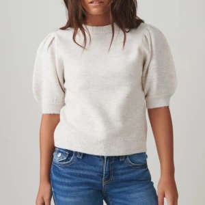 Beige stickad tröja med puffärmar - Säljer en stilren beige stickad tröja med puffiga kortärmar. Perfekt för en chic och avslappnad look. Tröjan har en rund halsringning och ribbade kanter. Från Gina Tricot. Oanvänd!