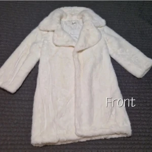 Vit pälsjacka från LOYO - Elegant vit pälsjacka från china LOYO med långärmad design och stor krage. Perfekt för att hålla sig varm och stilren under de kallare månaderna. Jackan har en klassisk look som passar till många olika tillfällen.