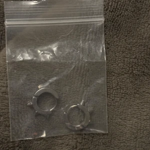 Silvriga örhängen med nitar - Coola silvriga örhängen med nitar i en edgy design. Perfekta för att ge din stil en tuff touch. Kommer i en praktisk plastpåse.