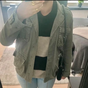 Jacka/kurtka - Snygg grön jacka med flera fickor och knappar framtill. Perfekt för en avslappnad stil. Jackan har en normal passform och långa ärmar.