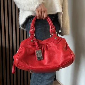 Marc Jacobs väska  - Marc Jacobs classic q baby groove med silvriga detaljer. Väskan är vermillion/röd. Axelremband ingår. Den är ca 30 cm bred och är i den lilla modellen. Mycket bra skick. Minimala scratches på lädret. Fler bilder finns och svarar gärna på frågor ❤️