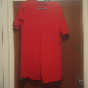 Röd klänning/ blus från Zara - Snygg röd klänning från Zara TRF Collection med korta ärmar. Perfekt för en färgstark look. Storlek L men stor i storleken  