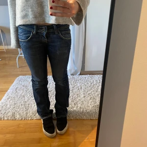 Blå jeans från Lee - Säljer ett par mörkblå jeans från Lee. De är lågmidjade. Jeansen har två knappar fram. Bra skick.