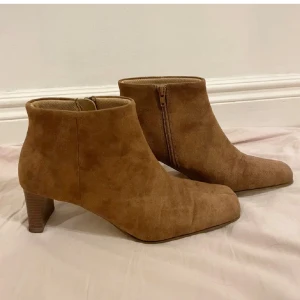 Klackskor med detalj - Säljer brun/beigea klackskor med dragkedja i storlek 39. Jag har fått dom så vet jag inte hur mycket dom är använda men sulan är smutsig/sliten men inget som påverkar. Kontakta mig vid frågor. Köparen betalar frakten!