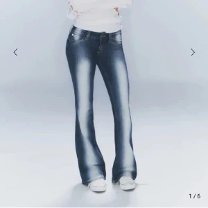 Blå weekday jeans med vita ränder - Snygga blå bootcut jeans med en klassisk femficksdesign och ljusa tvättade detaljer. Perfekta för en avslappnad stil med en touch av retro. De har en knapp- och dragkedjestängning. Slutsåld på hemsidan i nästan alla storlekar.