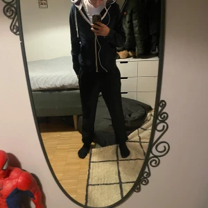 Pier one zip hoodie - Säljer en stilren mörkblå hoodie med dragkedja och vita snören. Perfekt för en avslappnad look. Den har en praktisk huva och fickor framtill.