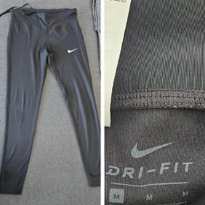 Svarta Dri-FIT leggings från Nike - Säljer ett par svarta Dri-FIT leggings från Nike. De är perfekta för träning med sin tighta passform och fukttransporterande material. Diskret Nike-logga på benet.