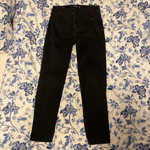 Svarta jeans från Hollister - Snygga svarta jeans från Hollister med en tapered passform. Perfekta för en stilren look. Tillverkade med avancerad stretch för extra komfort.