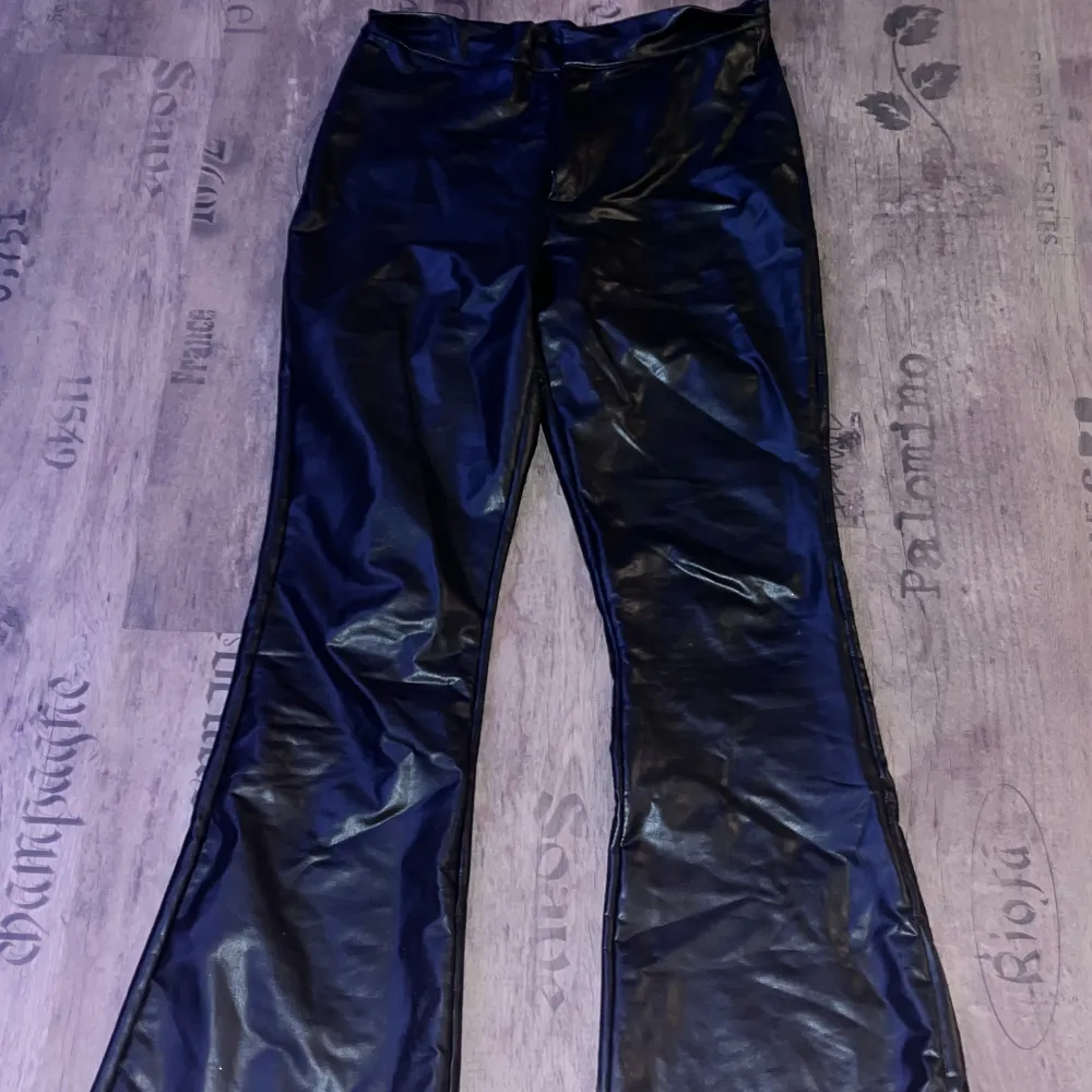 Snygga svarta skinnbyxor med bootcut-stil. Perfekta för en trendig look med hög midja och en skön passform.. Farkut & Housut.