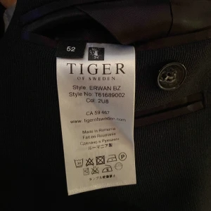 Mörkblå kavaj från Tiger of Sweden - Snygg mörkblå kavaj från Tiger of Sweden i stilren design. Dubbelknäppt med klassiska slag och knappar på ärmarna. Perfekt för en elegant look. Inköpt för ungefär 3999kr men använd bara en gång och sedan har den bara samlat damm i garderoben.