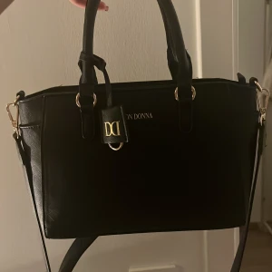 Svart läderväska från Don Donna  - Elegant svart handväska från Don Donna med guldtelajer. Rymmer mycket!💗
