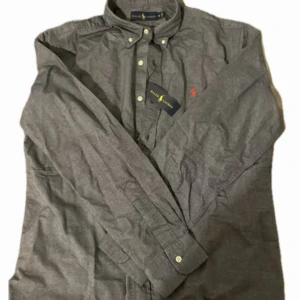 Grå skjorta från Ralph Lauren - En väldigt snygg och bekväm skjorta från ralph lauren i storlek M i en slags blå grå färg. Ny pris runt 1300kr+. Skriv vid funderingar och kan sänka vid snabb affär.