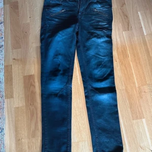 Blås  jeans från Emilio Denim - Snygga blåa jeans från Emilio Denim med en stilren design. Byxorna har en normal passform och är perfekta för en avslappnad look. De har dragkedja och knappar framtill.