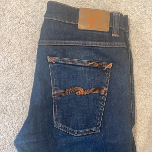 Jeans från Nudie Jeans - Snygga mörkblå jeans från Nudie Jeans, sparsamt använda och har nu växt ur dem, väldigt bra skick. Storlek 34/32 nypris 1500