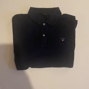 Marinblå pikétröja från Gant - Säljer nu denna snygga piké från gant. Piké är i väldigt fint skick. Hör av er vid frågor eller funderingar💭🤩